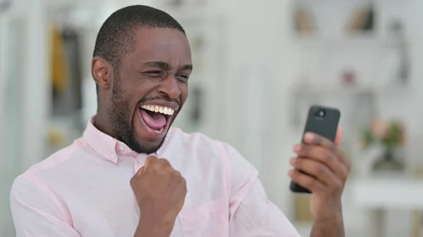 非洲男人用智能手机庆祝胜利的肖像 — 图库照片