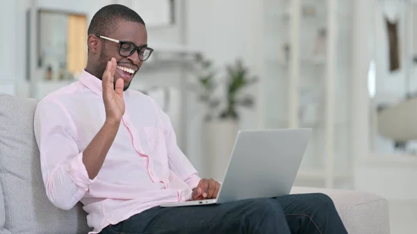 Attraktiv afrikansk man gör videosamtal på laptop hemma — Stockfoto