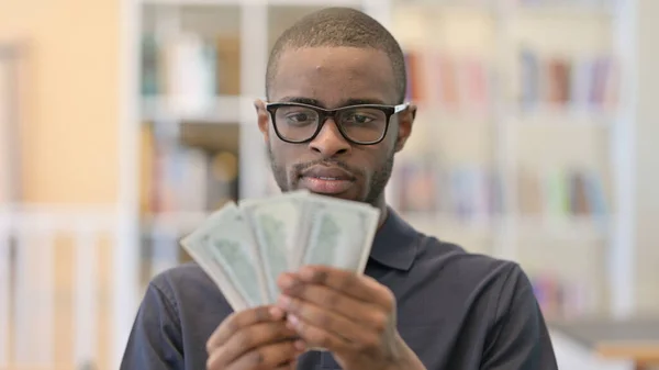 Retrato de un joven africano exitoso que cuenta dólares — Foto de Stock