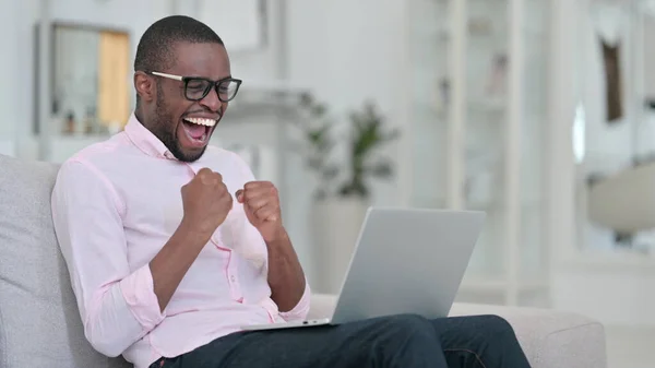 Ganando, Hombre Africano celebrando el éxito en el ordenador portátil en casa —  Fotos de Stock