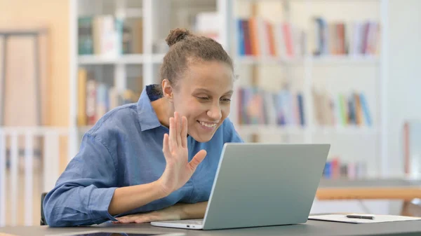 Professionell afrikansk kvinna gör videosamtal på laptop i biblioteket — Stockfoto