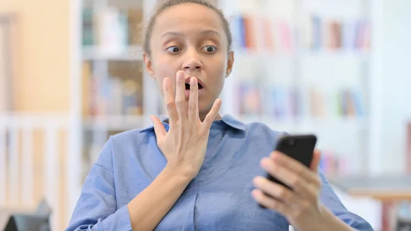 Retrato de mujer africana sintiéndose conmocionada usando Smartphone — Foto de Stock