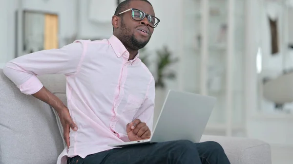 Exhausted African Man with Laptop having Back Pain at Home — Stock Photo, Image