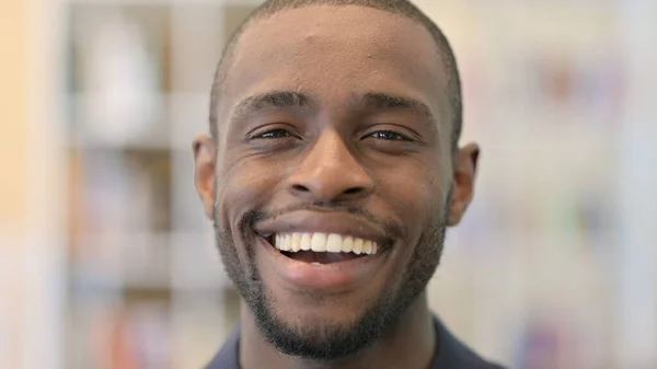Närbild av leende ung afrikansk man tittar på kameran — Stockfoto