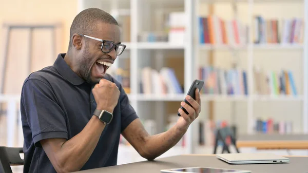 雄心勃勃的非洲年轻人在智能手机上庆祝成功 — 图库照片