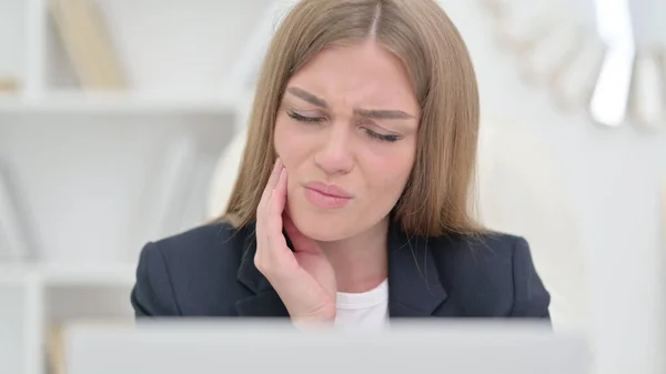 Giovane donna d'affari con computer portatile con mal di denti — Foto Stock