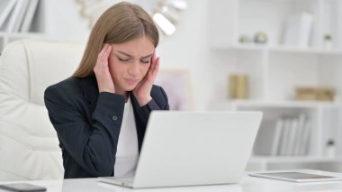 Dizüstü bilgisayarlı stresli iş kadını ofiste baş ağrısı çekiyor 