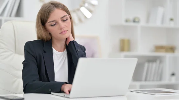 Donna d'affari stanca con computer portatile con dolore al collo in ufficio — Foto Stock