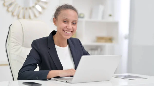 Attraktiv afrikansk affärskvinna med bärbar dator Tittar på kameran i Office — Stockfoto