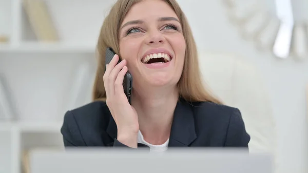 Donna d'affari ridente con computer portatile che parla al telefono — Foto Stock