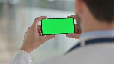 Erkek Doktor Chroma Screen ile Akıllı Telefon İzliyor 