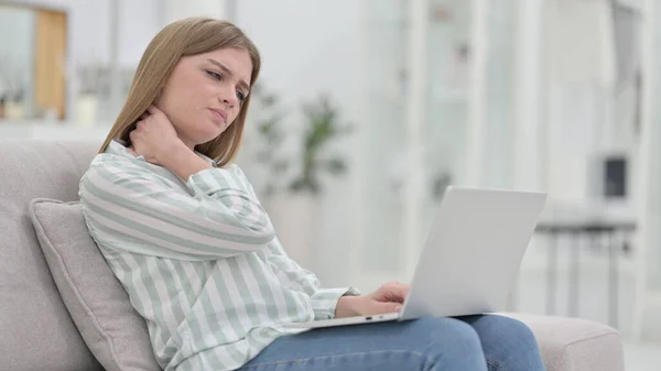 Unavená mladá žena s notebookem s bolestí krku doma — Stock fotografie