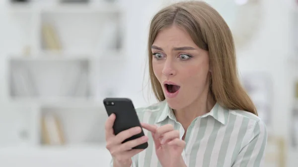 Retrato de mujer joven emocionada en maravilla usando Smartphone — Foto de Stock