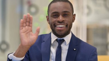 Kameraya el sallayan neşeli Afrikalı iş adamının portresi 