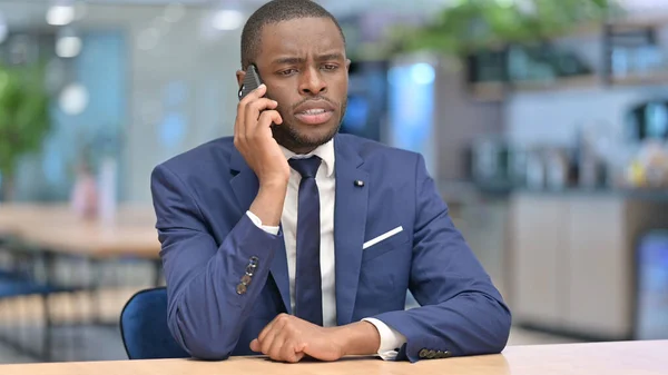 Empresario africano hablando por teléfono en la oficina —  Fotos de Stock