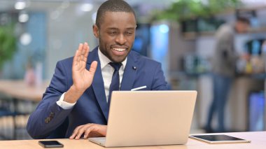 Ofisteki laptopta video görüşmesi yapan mutlu Afrikalı İşadamı 