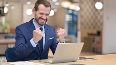 Ofisteki Dizüstü bilgisayarda Başarı Kutlaması Heyecanlı Orta Çağ İşadamı 