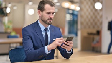 Ofiste Smartphone kullanan Ciddi Orta Çağ İşadamı 