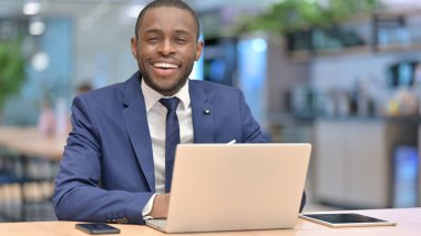 Laptoplu Afrikalı İşadamı Kafedeki Kameraya Gülümsüyor 