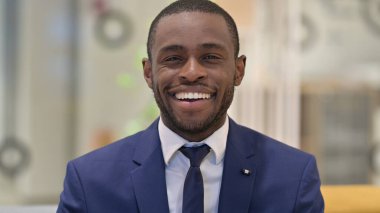 Kameraya gülümseyen neşeli Afrikalı iş adamının portresi