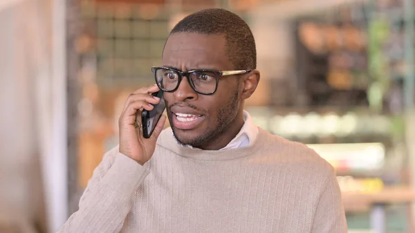 Porträtt av Arg afrikansk man talar i telefon — Stockfoto
