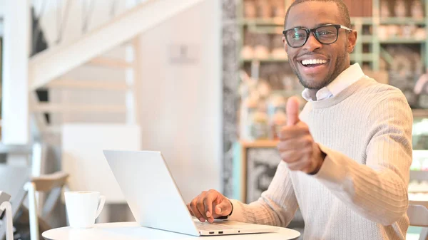 Tummen upp av afrikanska mannen som arbetar på laptop i Cafe — Stockfoto