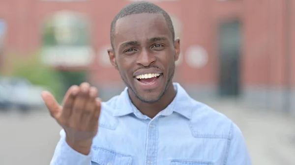 Portret van de jonge Afrikaanse man die mensen uitnodigt — Stockfoto