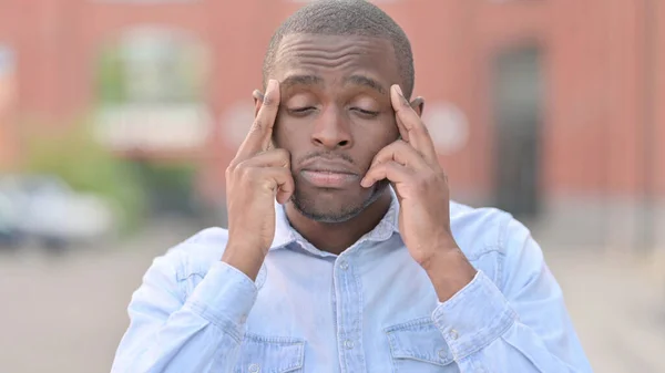 Retrato de un joven africano cansado con dolor de cabeza —  Fotos de Stock