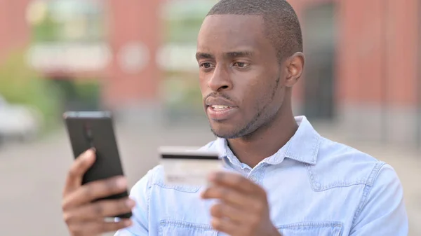 非洲男人在智能手机上在线付款的肖像 — 图库照片