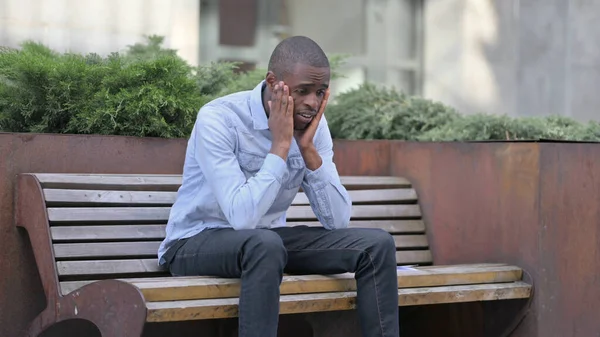 African Man Frustrated and Disappointed after Reading Documents outdoor