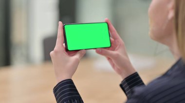 Krom Ekran ile Akıllı Telefon İzleyen İş Kadını Arka Görünümü
