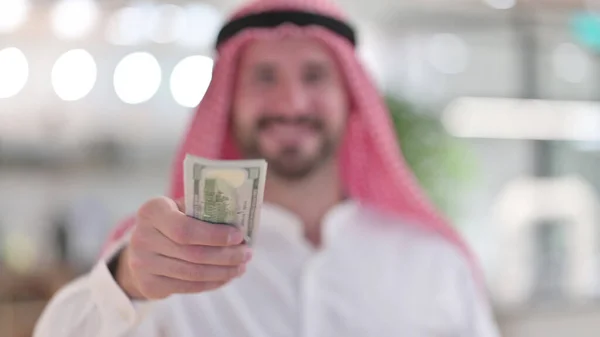 Uomo d'affari arabo che offre dollari, investimento finanziario — Foto Stock