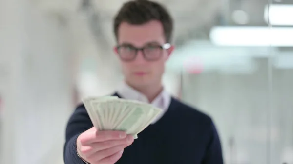 Succesvolle jonge zakenman die dollars weggeeft — Stockfoto