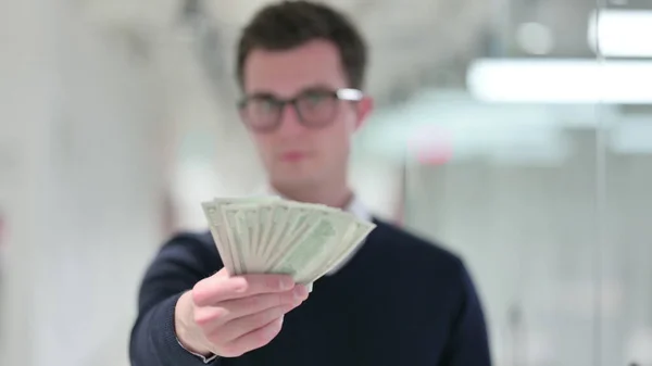 Professionele jonge zakenman toont dollars — Stockfoto