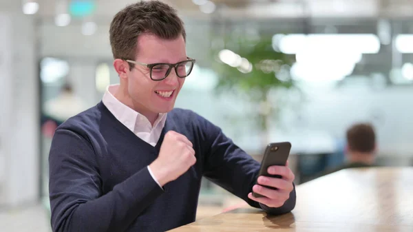 Mladý podnikatel slaví úspěch na chytrém telefonu — Stock fotografie