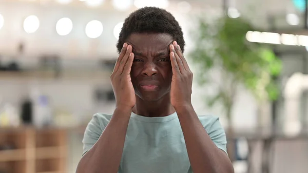 Retrato de un joven africano agotado con dolor de cabeza —  Fotos de Stock