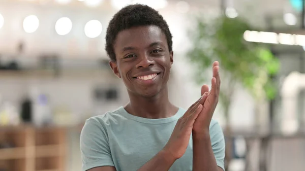 Porträt eines aufgeregten jungen Afrikaners, der klatscht und jubelt — Stockfoto