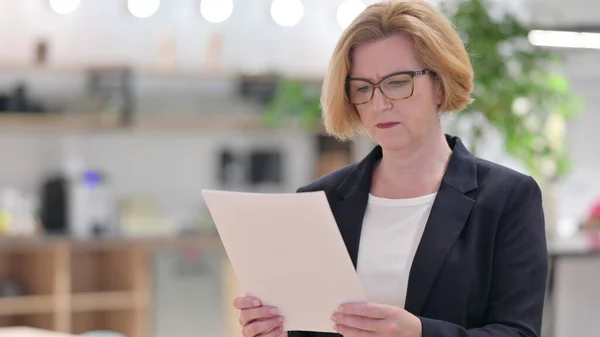 Retrato de una vieja empresaria leyendo documentos — Foto de Stock