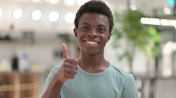 Porträtt av positiv ung afrikansk man gör tummen upp — Stockfoto