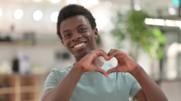 Porträtt av ung afrikansk man visar hjärttecken med handen — Stockfoto