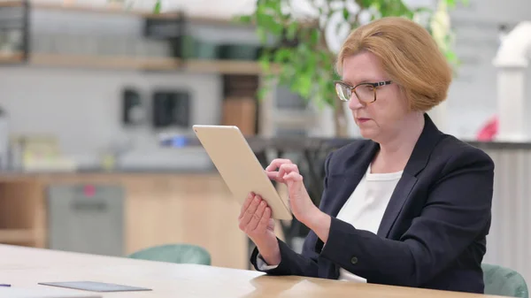 Grave donna d'affari che utilizza Tablet in ufficio — Foto Stock