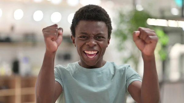 Retrato de un joven africano emocionado celebrando el éxito —  Fotos de Stock