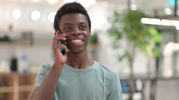 Porträtt av glad ung afrikansk man talar på smartphone — Stockfoto