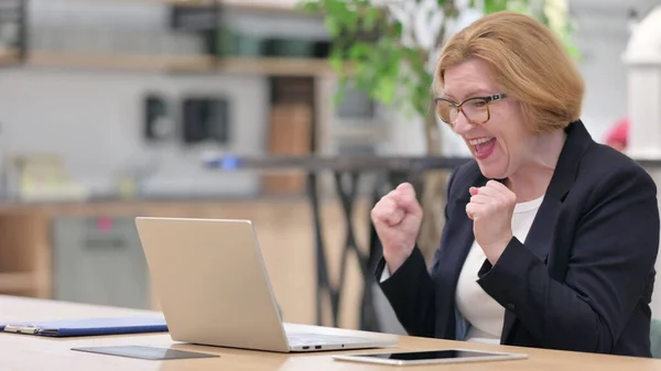 Excited Old Businesswoman having Success on Laptop in Office