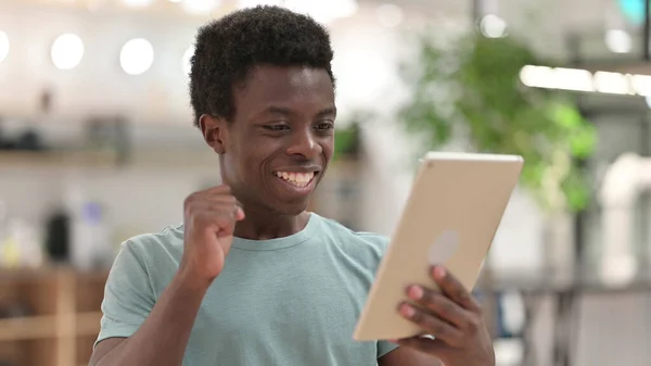 年轻的非洲人庆祝在平板电脑上的成功 — 图库照片