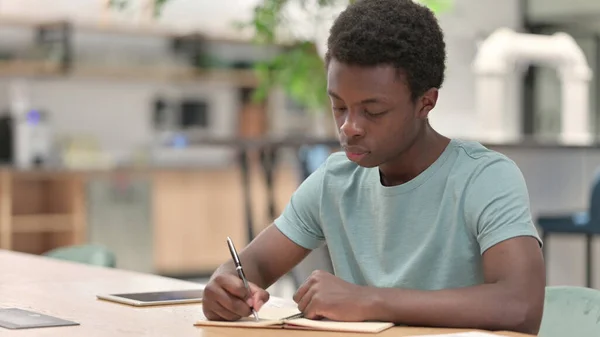 Homem Africano Jovem Escrevendo sobre Papel — Fotografia de Stock