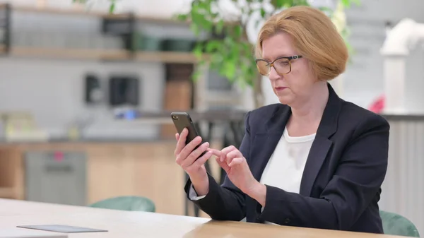 Donna d'affari seria che utilizza Smartphone in ufficio — Foto Stock