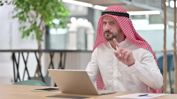 Seriózní arabský podnikatel s notebookem říká ne s prstem znamení — Stock fotografie