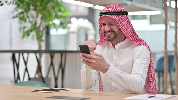 Arabische zakenman viert succes op smartphone — Stockfoto