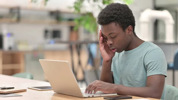 Stressad ung afrikansk man med bärbar dator har huvudvärk — Stockfoto